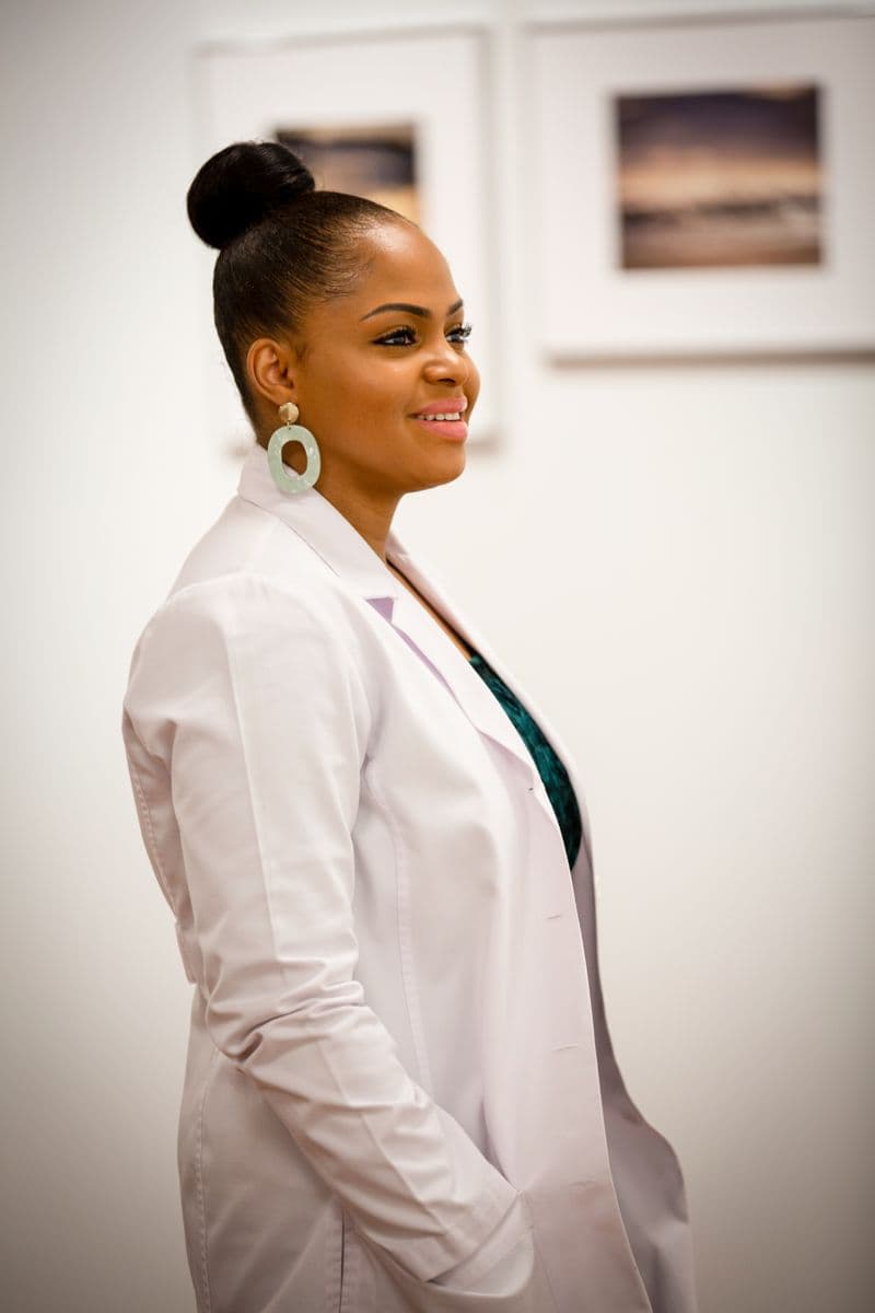 Portrait of Dr. Naomi Okafor smiling in a white clinical coat